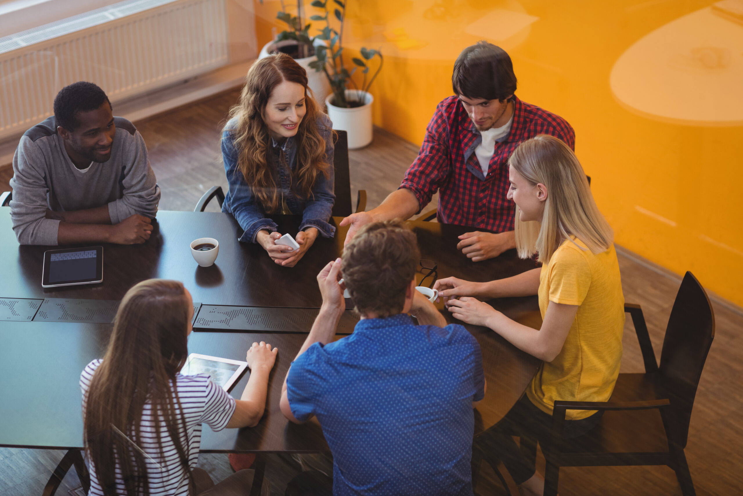 Business executives interacting with each other while having coffee in office